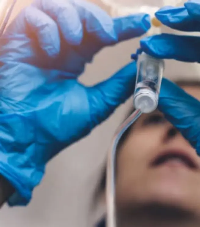 врач вводит лекарство в капельницу