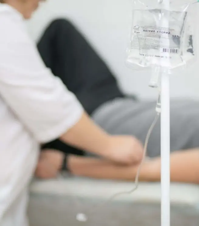 врач с пациентом на фоне капельницы